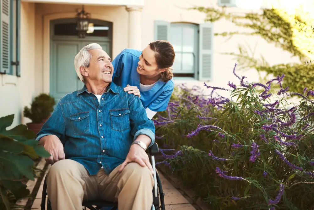 Nurse assist elderly senior man to drink coffee with mug in hand at nursing home<br />
