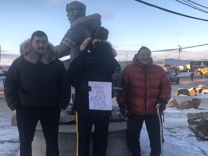 From left: Qikiqtani Inuit Association president Olayuk Akesuk, RCMP Chief Supt. Amanda Jones and artist Looty Pijamini stand in front of the monument commemorating Inuit special constables and their qimmiit. (Photo by David Lochead)